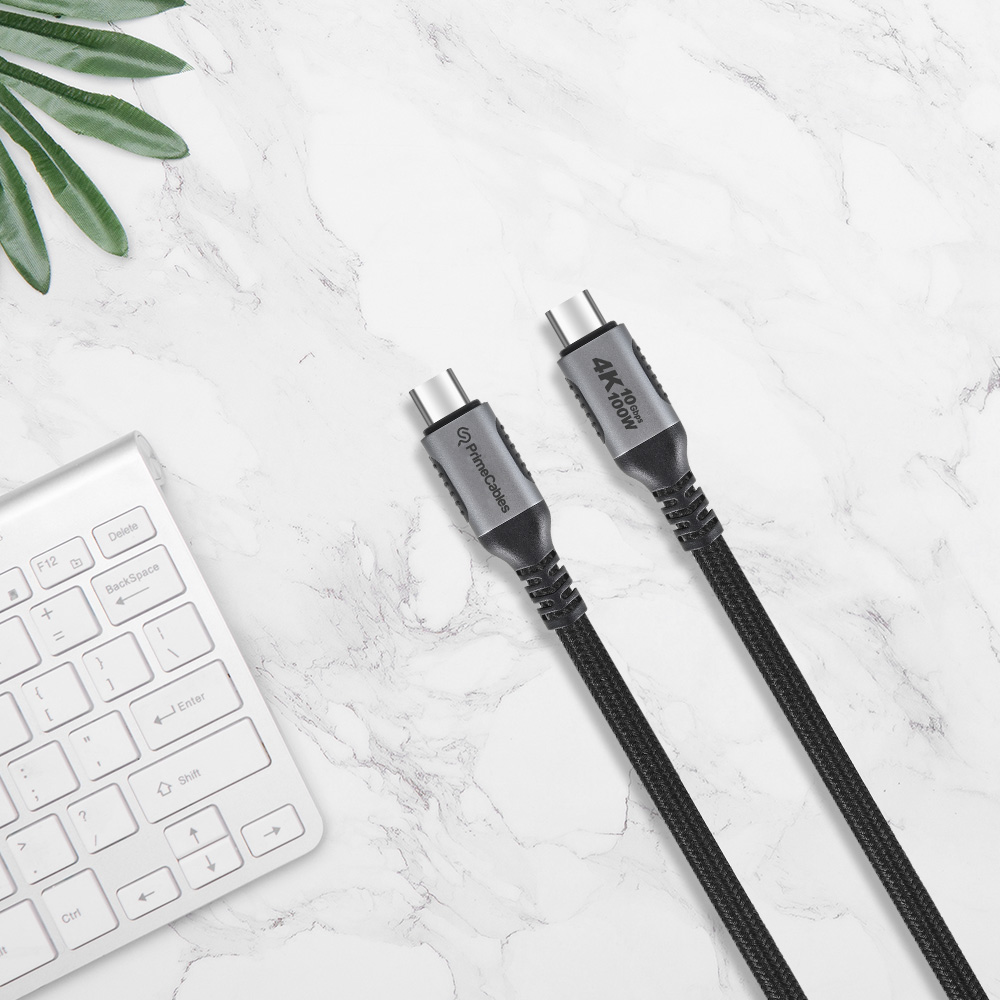 A 4K 100W black braided USB Type-C to Type-C cable is placed beside a white keyboard
