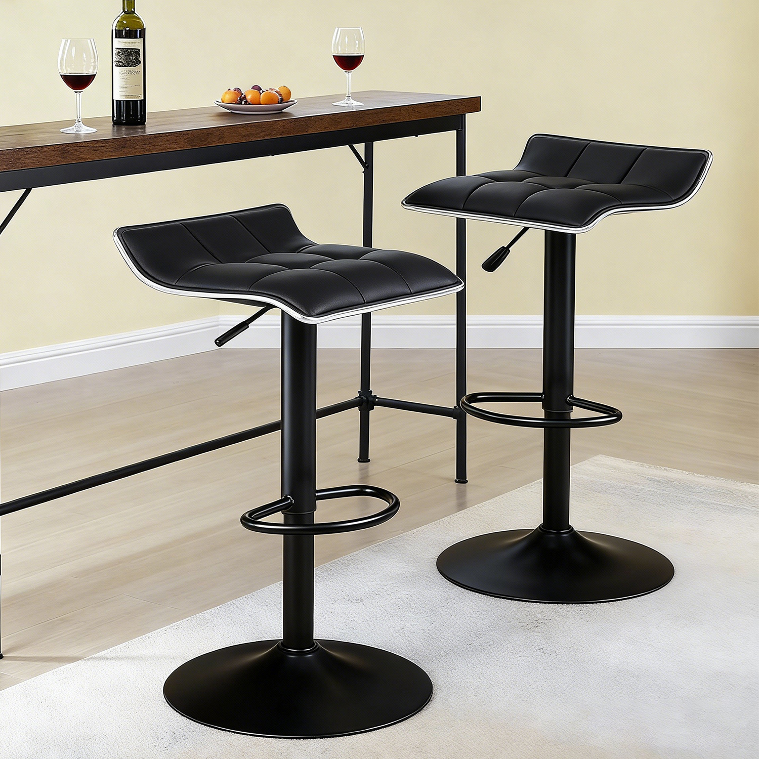 Two black backless adjustable leather swivel bar stools positioned beside a wooden high bar table