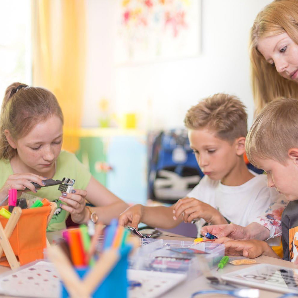 Group of children are building circuits and learning electronics by using electronic components kit