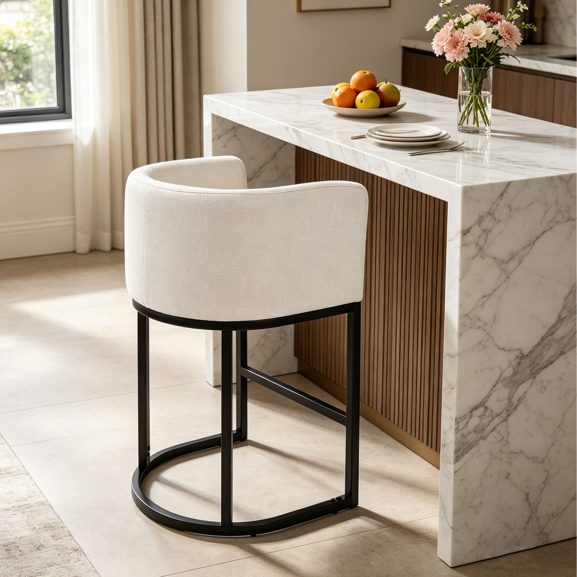 A beige barrel-shaped upholstered bar stool is placed beside a white marble kitchen island in a modern room
