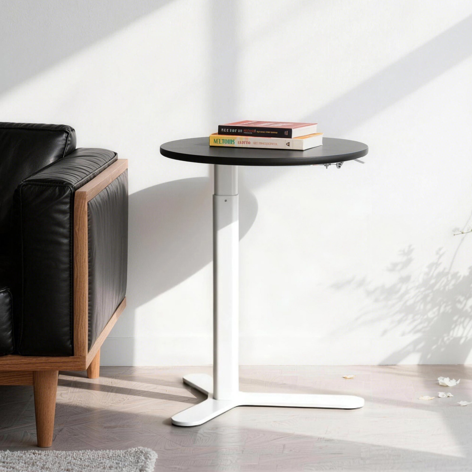 PrimeCables adjustable round side table with black desktop can be placed next to leather armchair