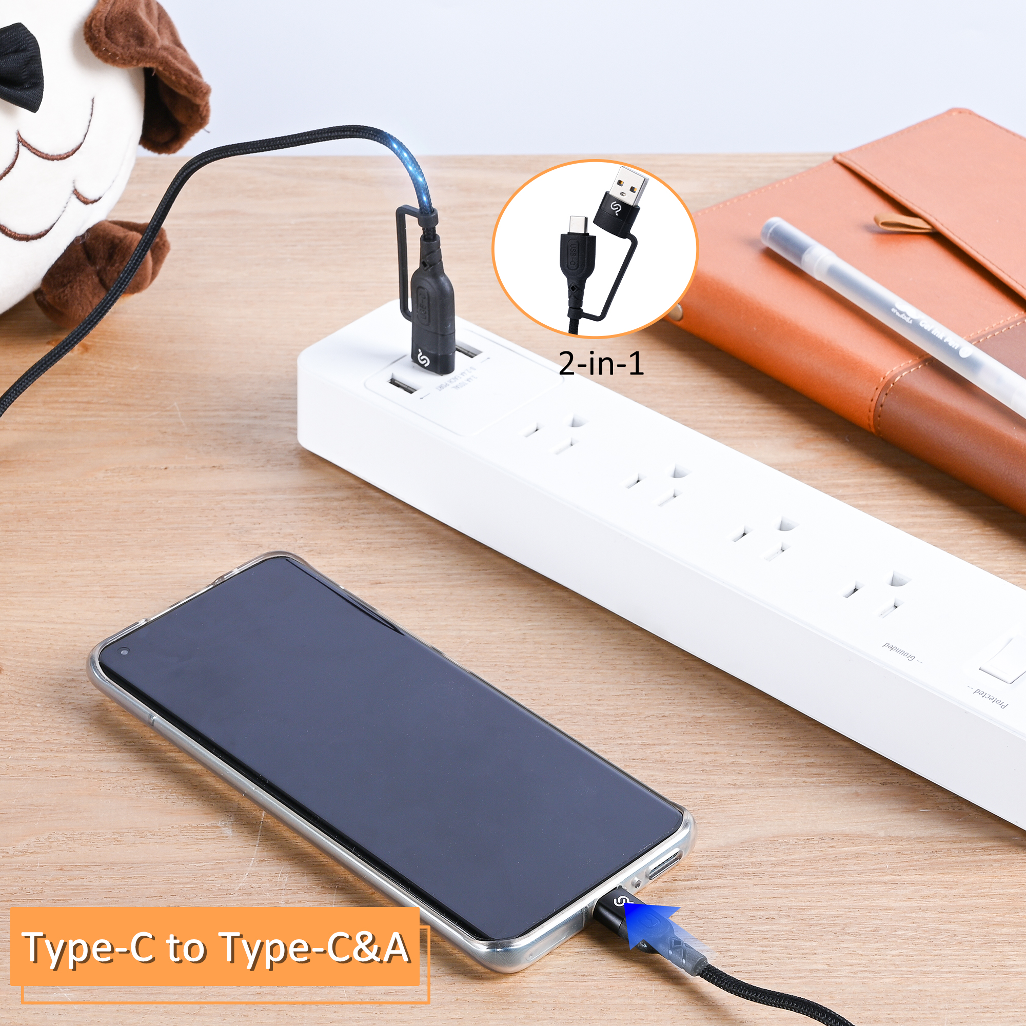USB-C and USB-A to USB-C cable plugged into a power strip and the smartphone on a desk, showing dual connector compatibility